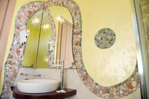 a bathroom with a sink and a large mirror at Agriturismo La Pecora Nera in Mulazzano