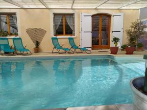 una piscina con sillas azules en Gites l’Olivier avec piscine en Vallon-Pont-dʼArc