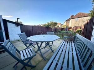 a picnic table and two chairs on a patio at Charming 3-bedroom family home in London