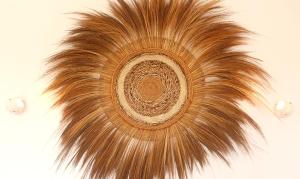 a large brown feather hanging on a wall at Aurora Boutique Hotel Jambiani in Jambiani