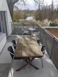 einen Holztisch und Stühle auf dem Balkon in der Unterkunft Wasserblick Stadtidyll 3 Zimmer Apartment Lübeck in Lübeck