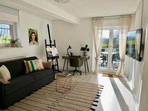 a living room with a black couch and a table at Art-Apartment with Terrace in Monschau in Monschau