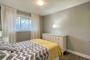 1 dormitorio con 1 cama con tocador y ventana en White House Suite - Sleeps 4, en St. Catharines