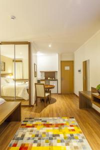a bedroom with a bed and a table in a room at São Carlos Marklin Suítes in São Carlos +40 photos
