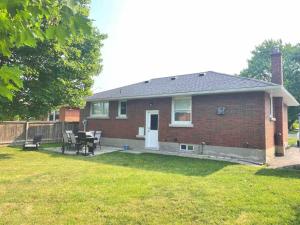 a brick house with a table and chairs in a yard at White House Suite - Sleeps 4 in St. Catharines