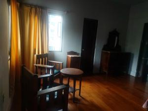 Zimmer mit einem Tisch, Stühlen und einem Fenster in der Unterkunft Global Family Backpackers Hostel in Lima