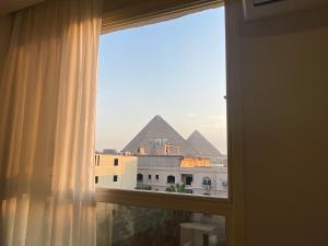 una finestra con vista sulle piramidi di un hotel di Diyar Pyramids Inn a Il Cairo