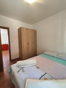 sypialnia z 2 łóżkami i drewnianą szafką w obiekcie Apartment by the sea w mieście Njivice