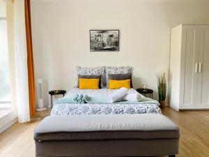 1 dormitorio con 1 cama grande con almohadas amarillas en Studio Cosy au pied de la gare de Cergy le Haut - 35 min de Paris en Cergy