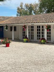 une maison blanche avec des fleurs devant elle dans l'établissement Mas de la pie, à Saintes-Maries-de-la-Mer