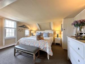 a bedroom with a bed with a teddy bear on it at Ship's Knees Inn in East Orleans