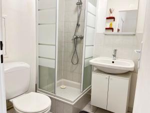 a bathroom with a shower and a toilet and a sink at Studio Cosy au pied de la gare de Cergy le Haut - 35 min de Paris in Cergy