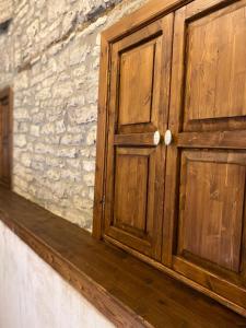 a wooden door on the side of a stone wall at Doda Guest House in Gjirokastër +73 photos