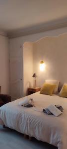 um quarto com uma grande cama branca e um candeeiro em Propriété avec piscine de 2 à 9 personnes, Gîte De Saint Donat, em La Roque-Gageac