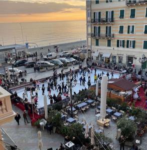 un grupo de personas caminando alrededor de una plaza cerca de la playa en Hotel Astigiana & Appartamenti, en Varazze