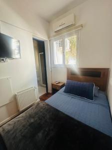 a bedroom with a blue bed and a window at Maktub Europa - Hostal Boutique in Santiago