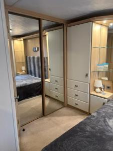 Schlafzimmer mit Spiegelschränken und einem Bett in der Unterkunft Foxgloves and Ivy in Cockermouth