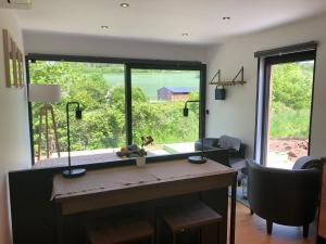 Zimmer mit einem Schreibtisch und einem großen Fenster in der Unterkunft Les Tiny House du Mas de Mont in Mont