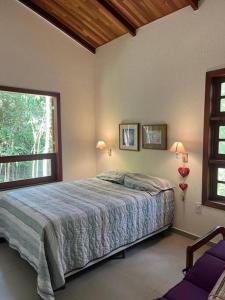 Un dormitorio con una cama y una ventana grande en Chalé Carolina Bela, en Guaramiranga