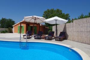 una piscina con 2 sombrillas y 2 sillas en Ferienhaus in Vodnjan mit Privatem Pool, en Vodnjan