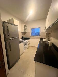 una cucina con frigorifero in acciaio inossidabile e mobili bianchi di Departamento en pleno centro de Corrientes a Corrientes