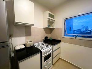 a small kitchen with a stove and a window at Departamento en pleno centro de Corrientes in Corrientes