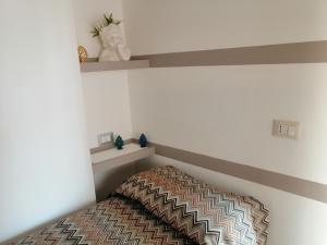 ein kleines Schlafzimmer mit einem Bett in einer Ecke in der Unterkunft La perla di nicolosi in Nicolosi