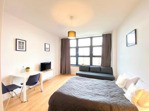 - une chambre avec un lit, une table et un bureau dans l'établissement Apartimento Hydral Fresco, à Wrocław