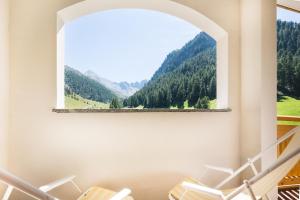 um quarto com uma janela com vista para a montanha em Chasa Castello relax & spa em Samnaun