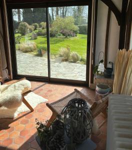 eine offene Tür zu einer Terrasse mit Blick auf einen Hof in der Unterkunft Maison de charme, près des plages du Débarquement in Bayeux
