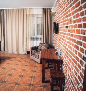 ein Wohnzimmer mit einer Backsteinwand und einem Tisch in der Unterkunft Fortetsya in Uman