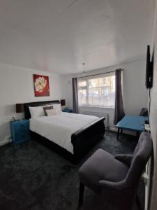 een slaapkamer met een bed, een stoel en een raam bij Beck's Sunset Accommodation in Dover