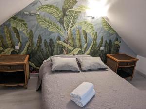 - une chambre avec un lit orné d'une fresque murale de cactus dans l'établissement Au Près du Zoo, à Saint-Aignan