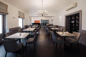 a restaurant with tables and chairs and a chandelier at Hotel Slatina in Rogaška Slatina