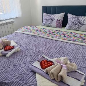 a bed with towels and fruit on top of it at Apartman LARA in Pirot