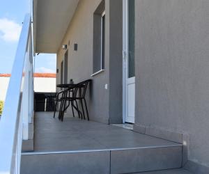 a balcony of a house with a table and chairs at Venice Apartments 2 in Limenaria