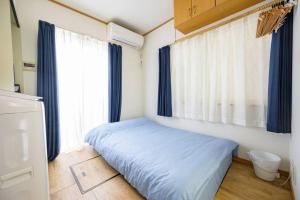 a small bedroom with a bed and a window at Premier suite Yoyogi front detached house in Tokyo