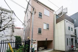 un gran edificio de ladrillo con un garaje delante de él en Premier suite Yoyogi front detached house en Tokio