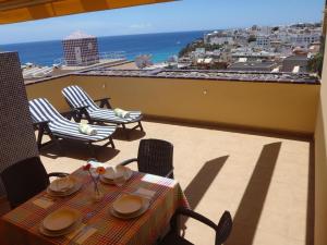 una mesa y sillas en un balcón con vistas al océano en Komfortable Ferienwohnung in Morro Jable mit Großer Terrasse und Neben dem Strand en Morro del Jable