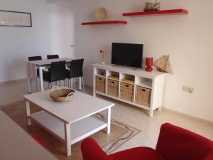 sala de estar con TV y mesa en Komfortable Ferienwohnung in Morro Jable mit Großer Terrasse und Neben dem Strand en Morro del Jable