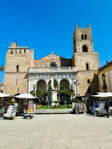 a large building with a tower and a market in front of it at Casa Lilla in Monreale