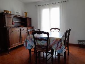 uma mesa de jantar com cadeiras e uma cómoda em Maison de Lili em Florensac