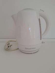 een witte koffiepot bovenop een magnetron bij B&B Bell'aria in Monopoli