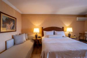 Likoria Hotel في أراخوفا: غرفة فندقية بسرير كبير ومصباحين