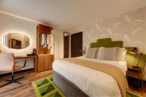 a hotel room with a large bed and a desk at Brama in Bromley