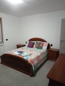 - une chambre avec un lit et une tête de lit en bois dans l'établissement Colli di Luni, à Luni