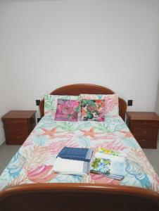 - un lit avec un couvre-lit coloré et des livres dans l'établissement Colli di Luni, à Luni