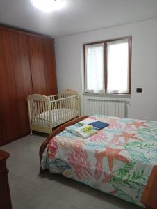 - une chambre avec un lit et deux lits bébé dans l'établissement Colli di Luni, à Luni