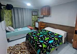 mały pokój z łóżkiem i stołem w obiekcie Pousada Amigos do Caetés w mieście Angra dos Reis