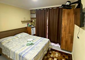 um quarto com uma cama com uma toalha em Pousada Amigos do Caetés em Angra dos Reis